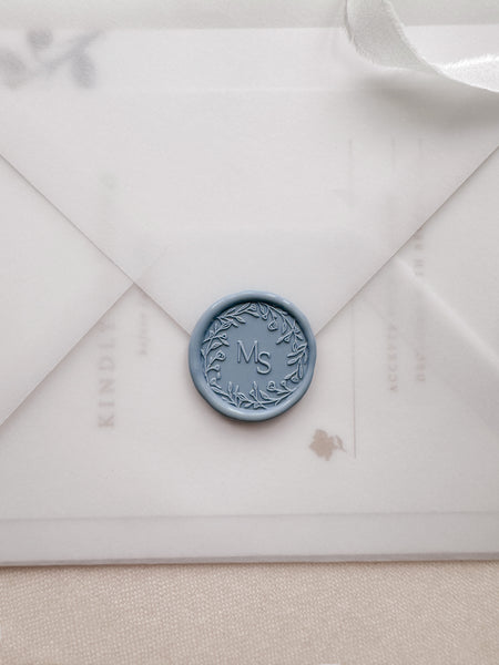 Floral wreath design monogram wax seal in color dusty blue on a vellum envelope
