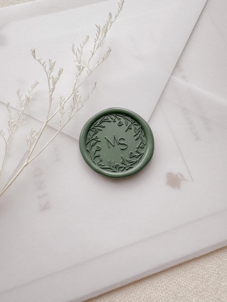 Floral wreath design monogram wax seal in color sage green on a vellum envelope