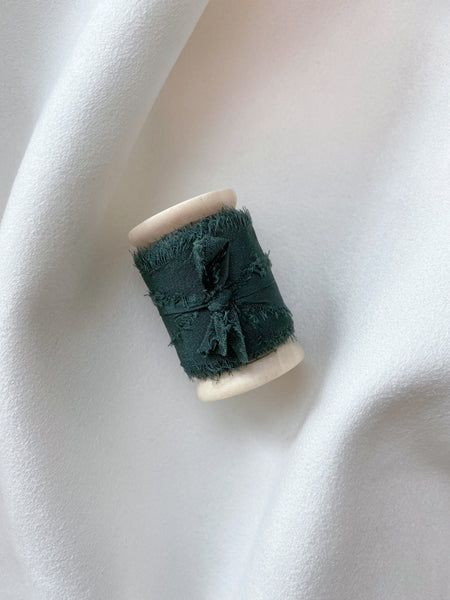 1 inch dark green silk ribbon on a wooden spool