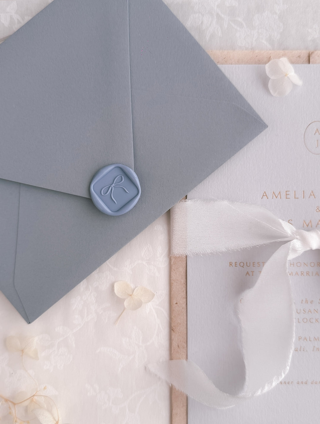 dusty blue 3D hand-drawn ribbon bow mini square wax seal on blue wedding envelope, and an wedding invitation card