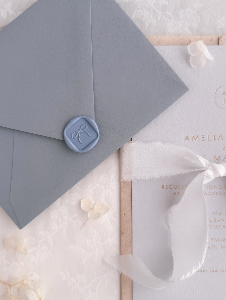 dusty blue 3D hand-drawn ribbon bow mini square wax seal on blue wedding envelope, and an wedding invitation card