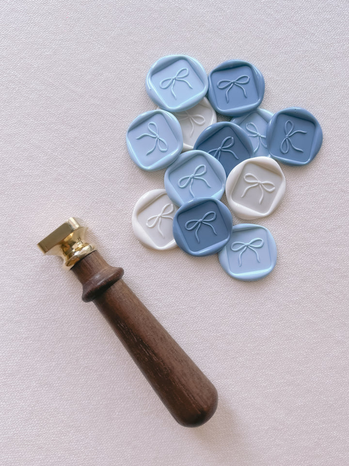blue and white ribbon bow design square shaped wax seals and a wax seal stamp 