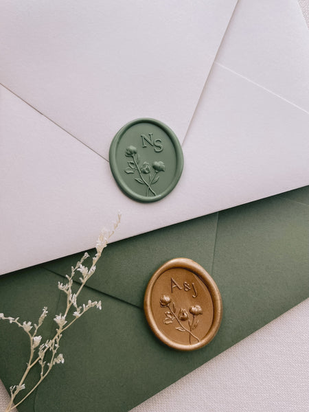 Green and gold custom initials oval floral monogram wax seals on beige and olive green envelopes 
