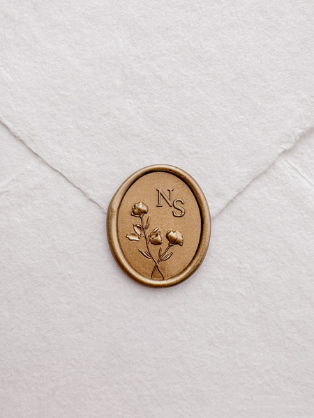 Personalized initials custom floral gold wax seal on a white envelope 