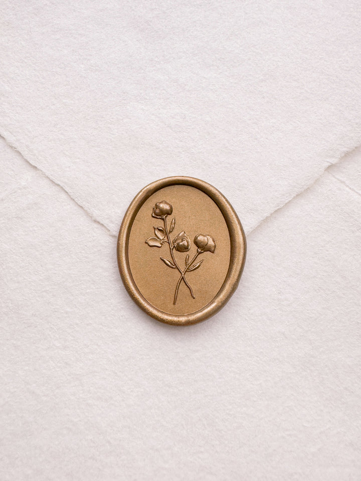 oval 3D floral gold wax seal on a white envelope