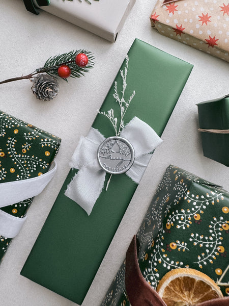 silver Merry Christmas wax seal on wrapped holiday gift