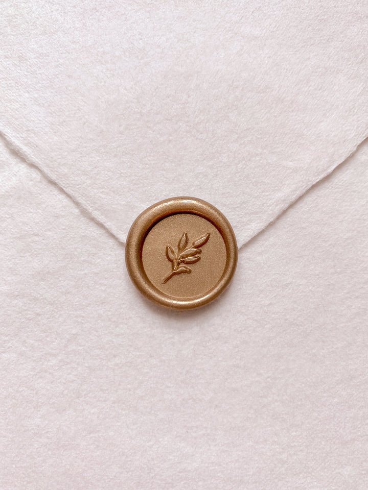 Gold mini leaf wax seal on beige handmade paper envelope