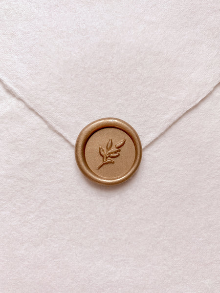 Gold mini leaf wax seal on beige handmade paper envelope