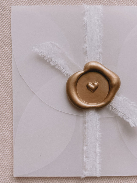 Gold mini 3D engraved heart wax seal on small vellum envelope embellished with white silk ribbon