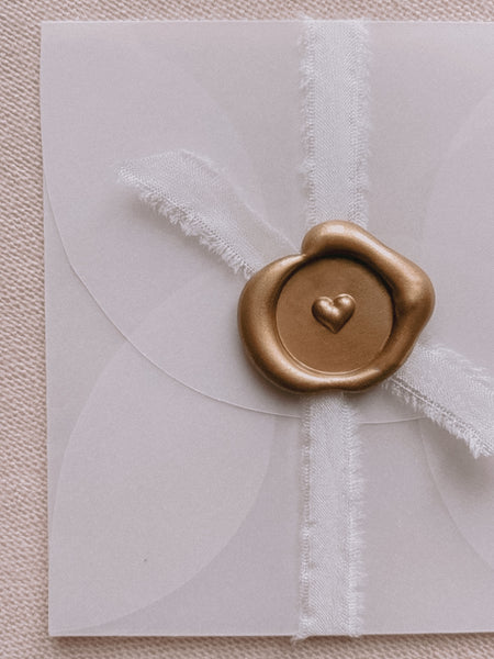 Gold mini 3D engraved heart wax seal on small vellum envelope embellished with white silk ribbon