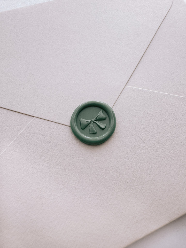 sage green 3D ribbon bow mini wax seal on a light beige envelope