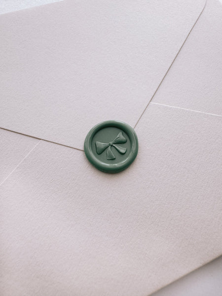 Sage green ribbon bow mini wax seal with 3D engraving on beige envelope