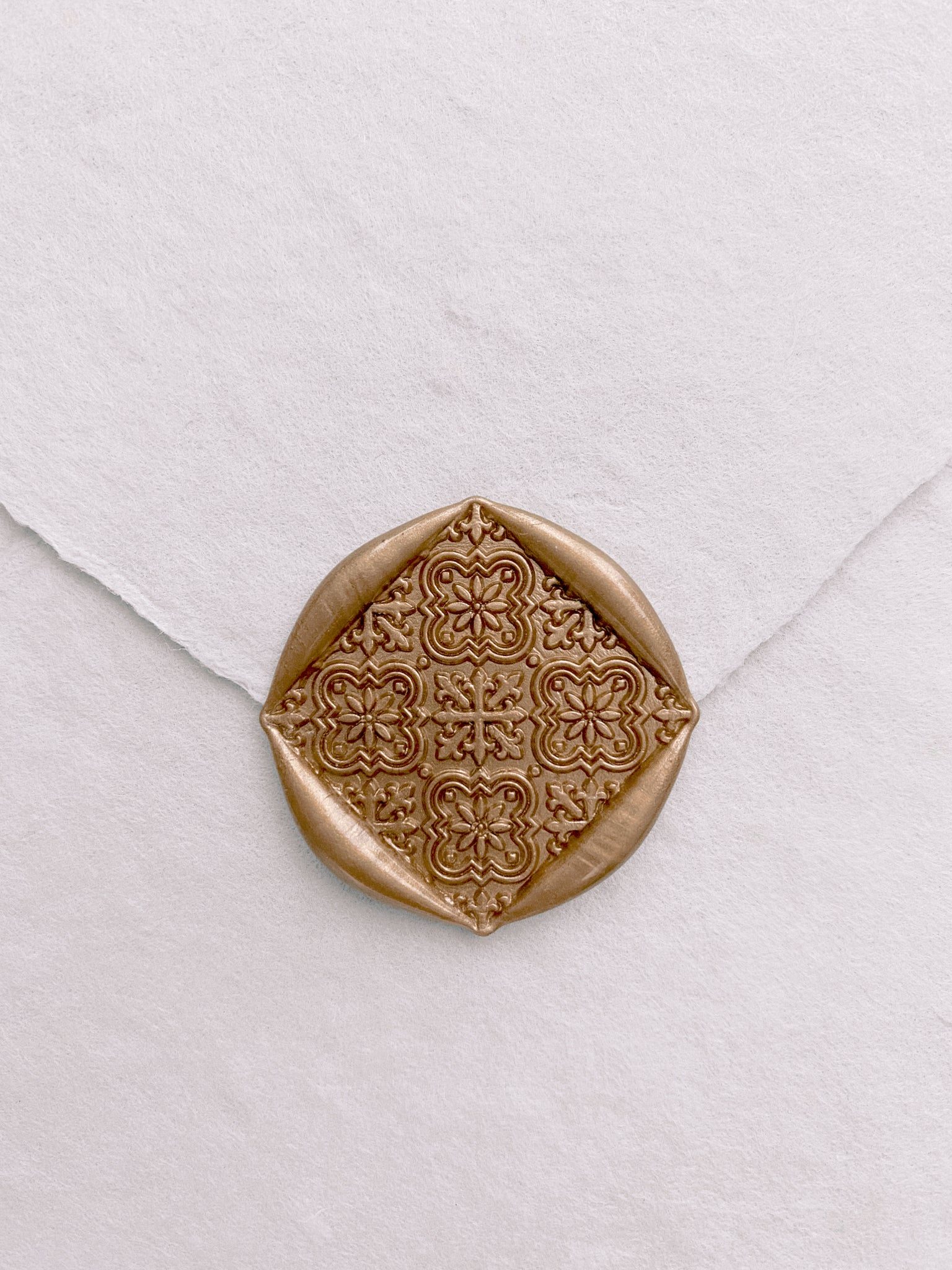 Moroccan tile pattern square shaped wax seals in gold on handmade paper white envelope_front angle