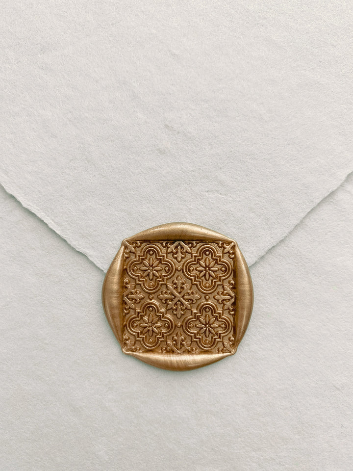 Moroccan tile pattern square shaped wax seal in gold on handmade paper envelope_close up front angle