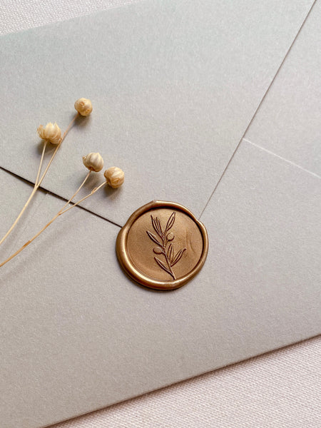 Olive branch gold wax seal on sage envelope styled with dried flowers