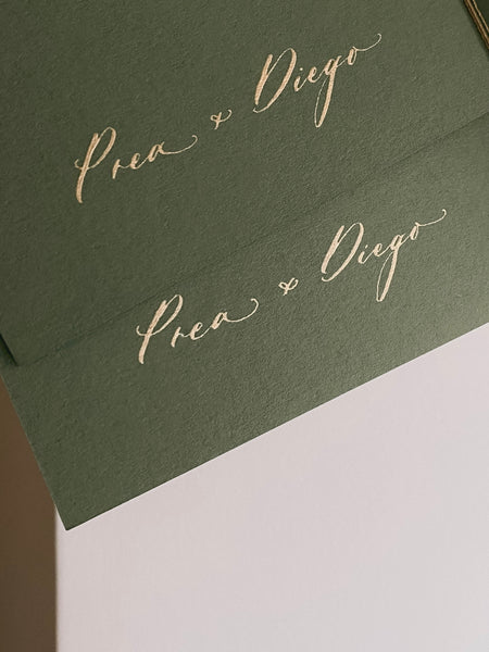 Olive green vow books showing inner cover personalized with the couple's names and wedding date in gold ink