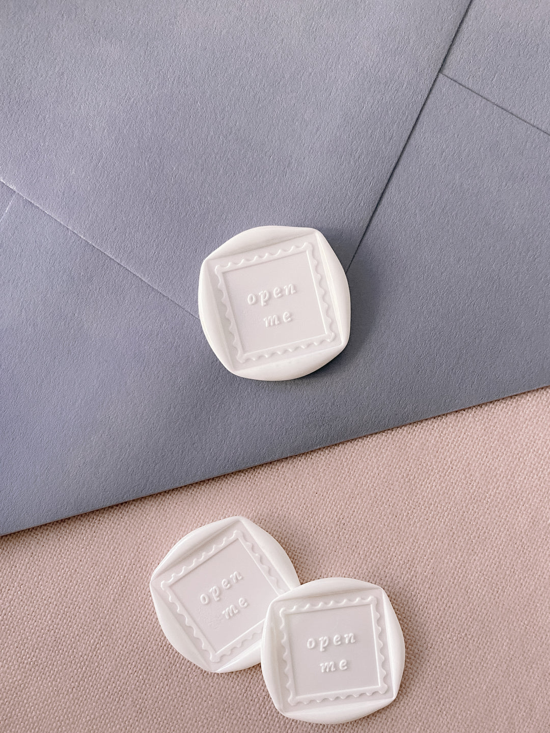 White Open Me wax seals on dusty blue envelope