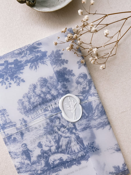 Off-white oval flower bouquet wax seal on blue printed vellum jacket