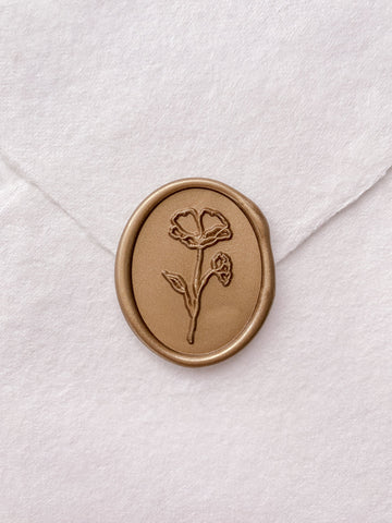 Oval flower wax seal in gold on handmade paper envelope