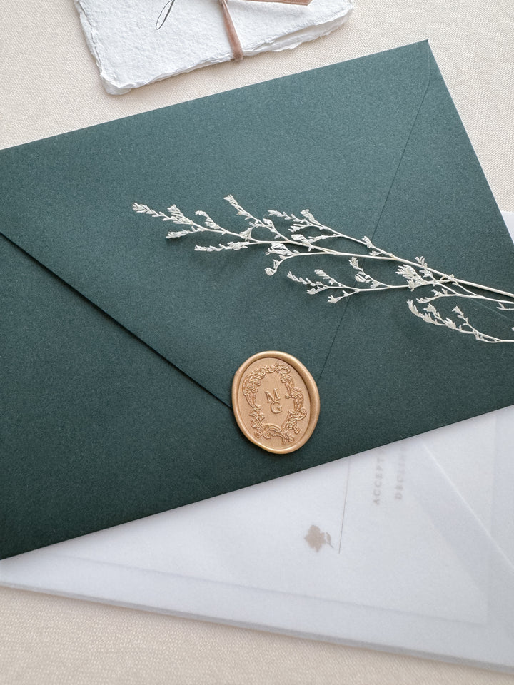 baroque crest design custom monogram gold wax seal on a dark green envelope