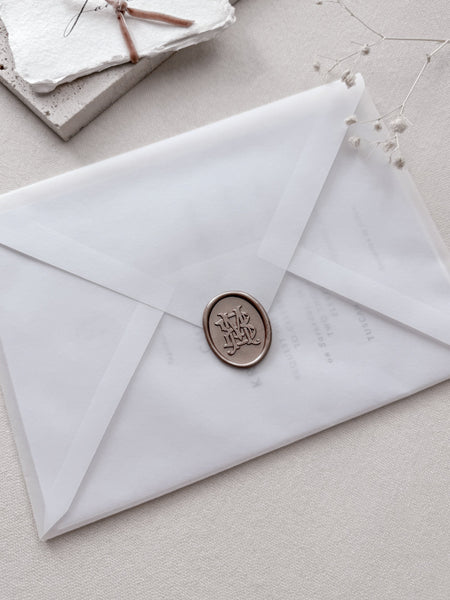 Light bronze oval vintage monogram wax seal on a vellum wedding invitation envelope