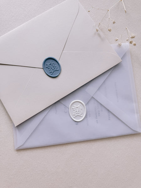 Dusty blue and white oval vintage monogram wax seals on envelopes