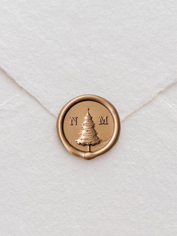 Personalized monogram gold wax seal with a Christmas tree design in the center and a custom initial on each side