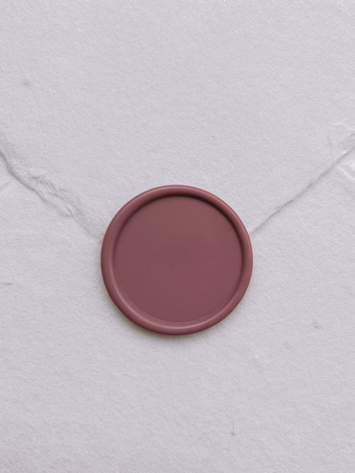 Antique rose colored blank wax seal on white handmade paper envelope