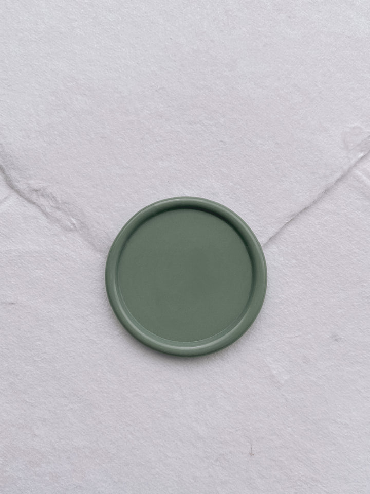 Sage green blank wax seal on white handmade paper envelope