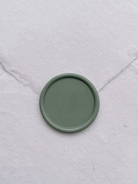 Sage green blank wax seal on white handmade paper envelope