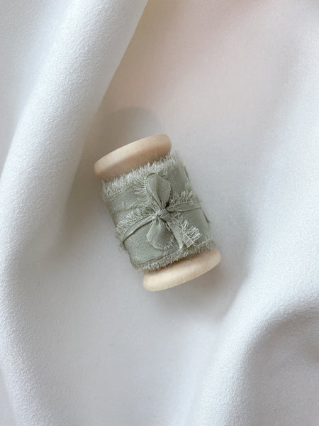 1 inch sage green silk ribbon on a wooden spool