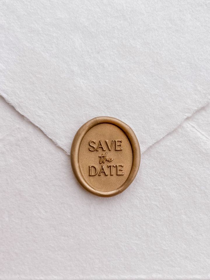 Gold save the date oval wax seal on white handmade paper envelope