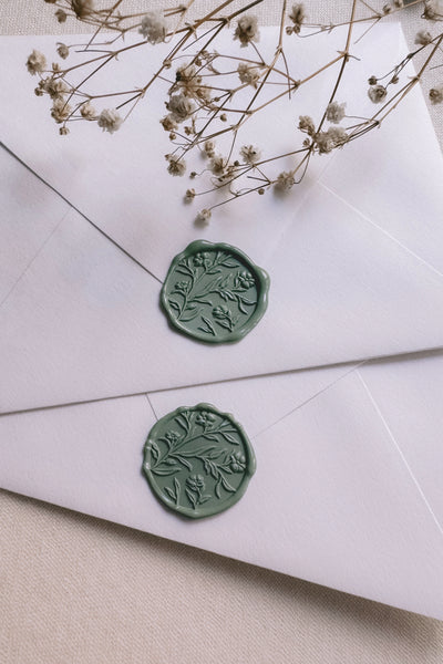Floral wax seals with 3D engraving in sage green on white paper envelopes styled with dried flowers