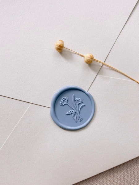 Dusty blue flower bouquet wax seal on beige paper envelope styled with dried flowers