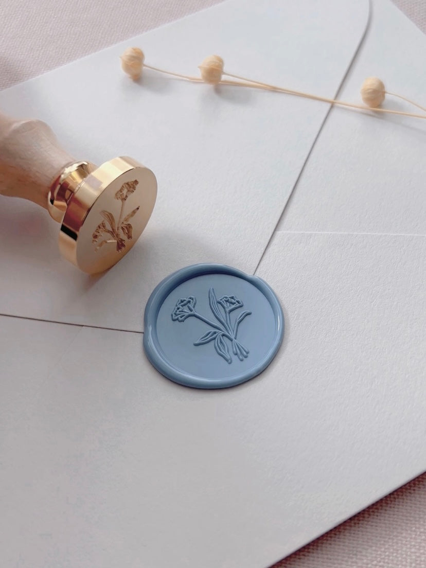 Flower bouquet wax seal in dusty blue on beige paper envelope styled with wax seal stamp and dried flowers