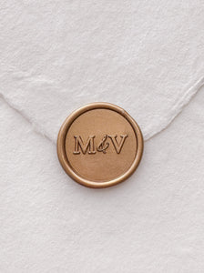 Typeface monogram gold wax seal on a white handmade paper envelope