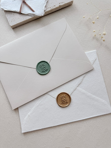 Sage green and gold vintage monogram wax seals on envelopes