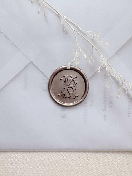 Light bronze vintage monogram wax seal on a vellum wedding invitation envelope