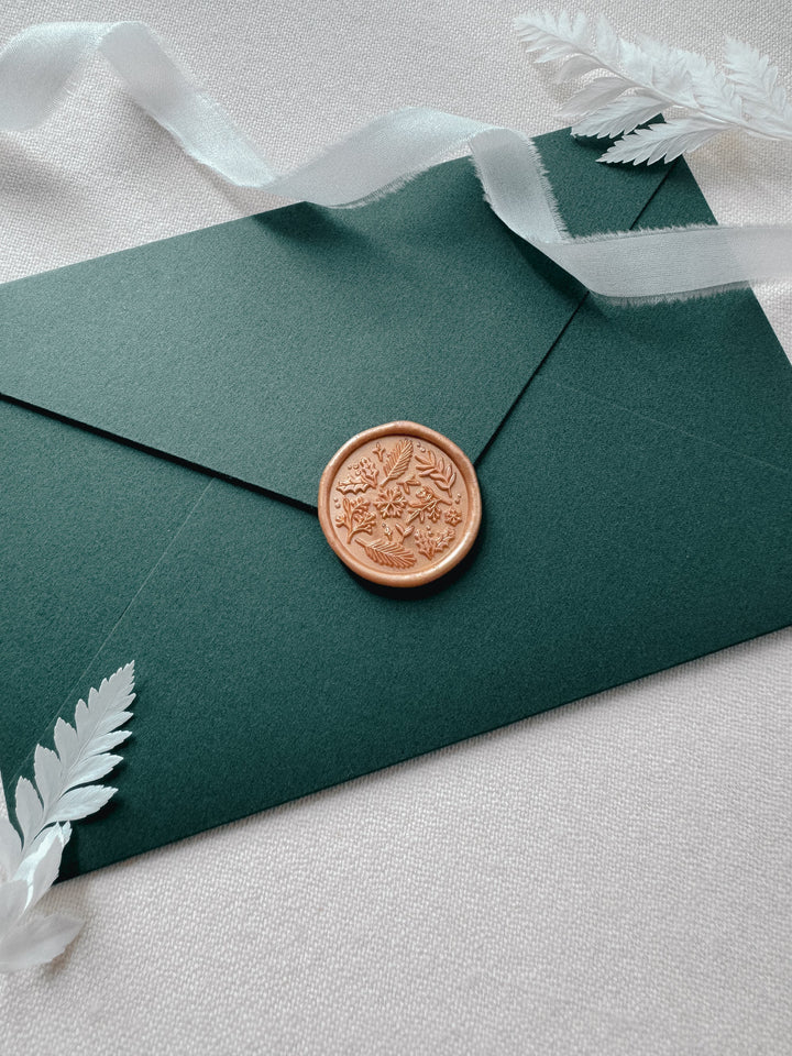 Christmas envelope seal featuring design of winter botanicals and snowflakes