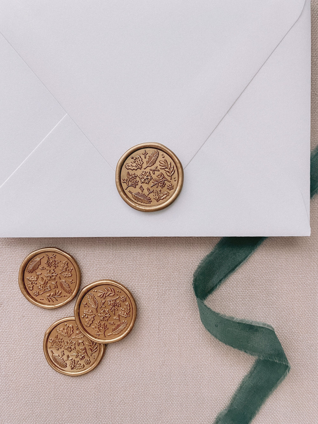 gold Christmas card seals featuring a festive winter foliage design