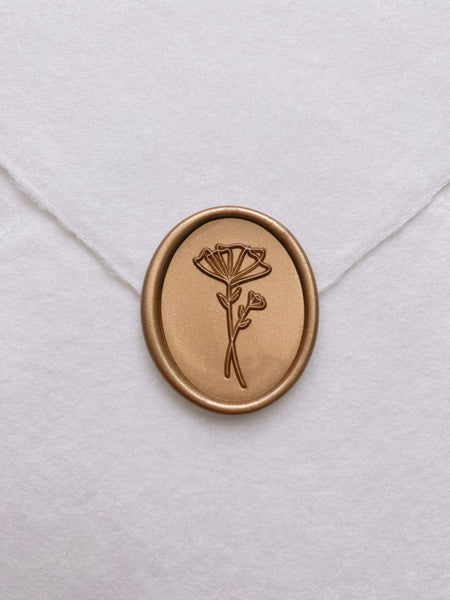 Abstract floral oval wax seal in gold on handmade paper envelope