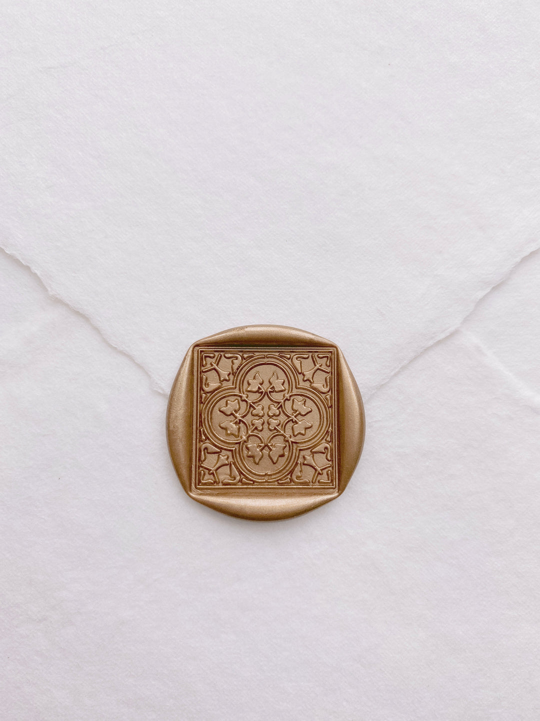 Moroccan tile quatrefoil pattern wax seal in light gold on beige handmade paper envelope