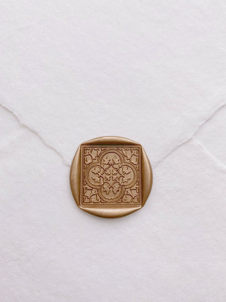 Moroccan tile quatrefoil pattern wax seal in light gold on beige handmade paper envelope