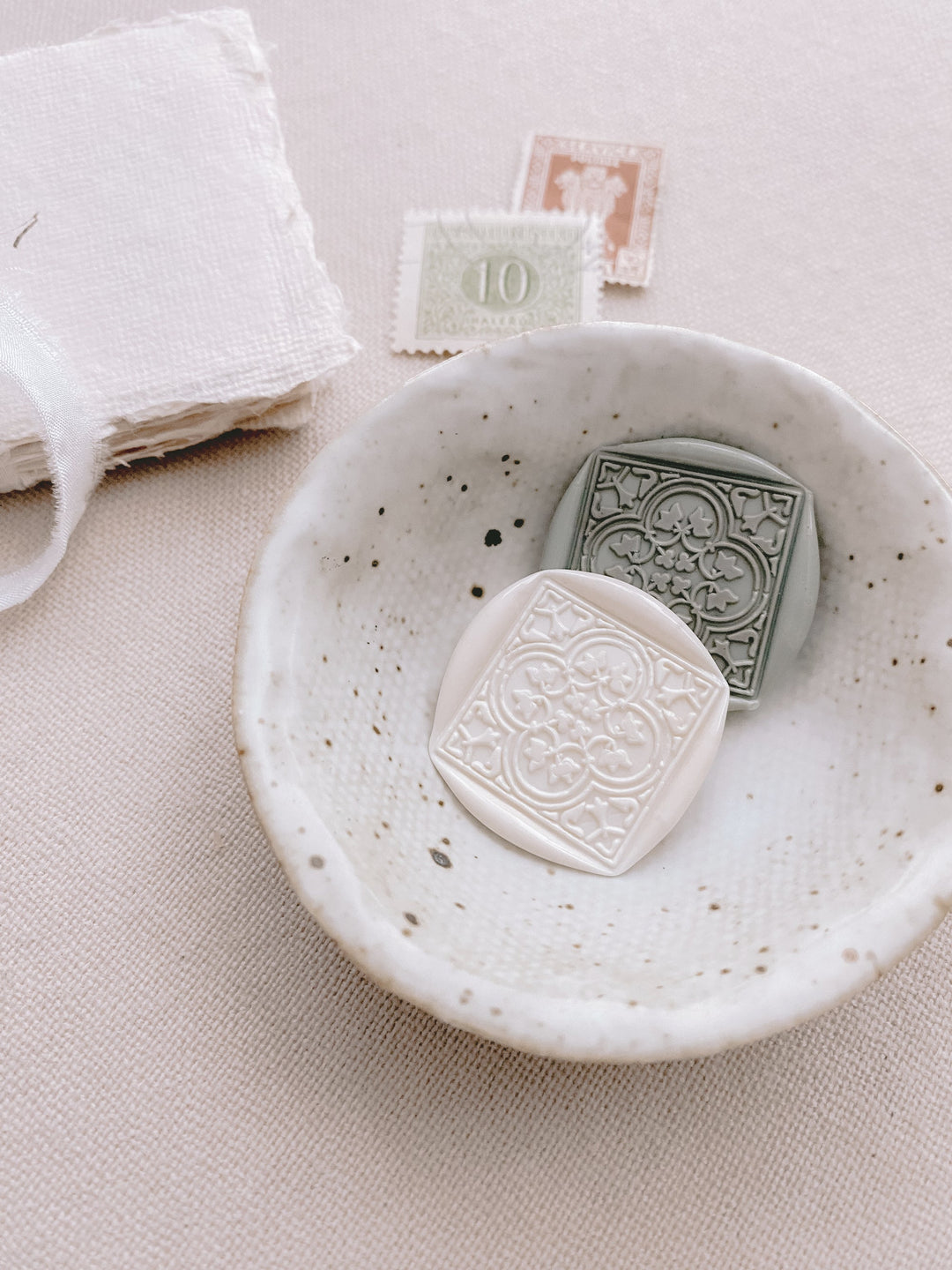 Moroccan tile quatrefoil pattern wax seals in off white and sage green in small bowl