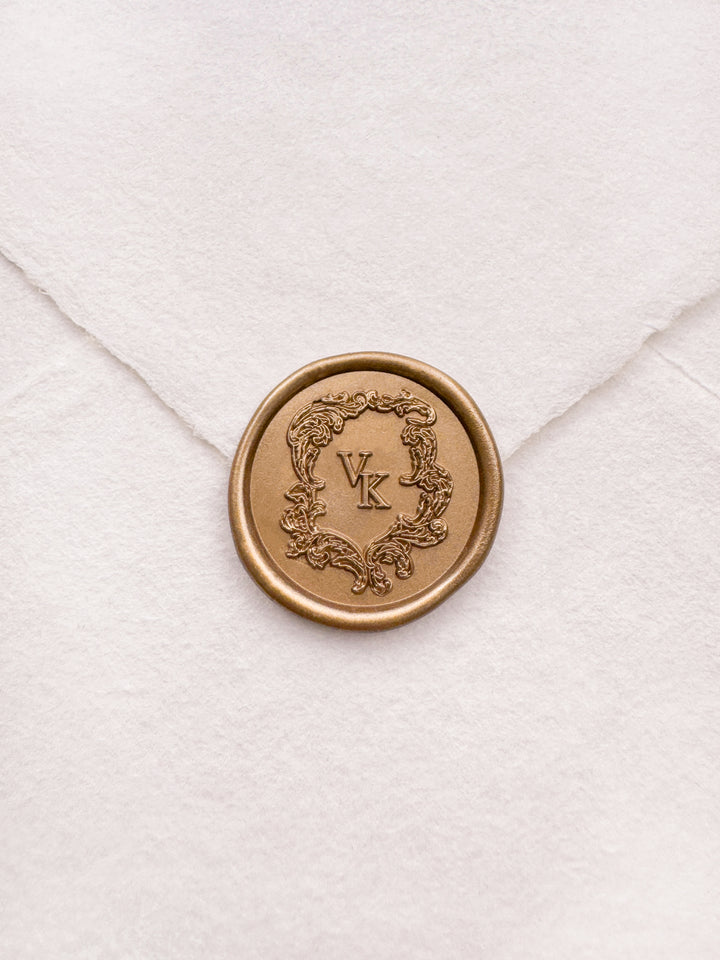 Baroque style vintage monogram gold wax seal on a white envelope