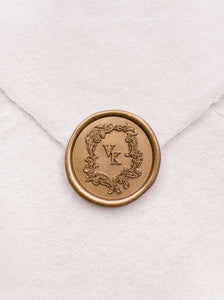 Baroque vintage crest design monogram gold wax seal on a white handmade paper envelope