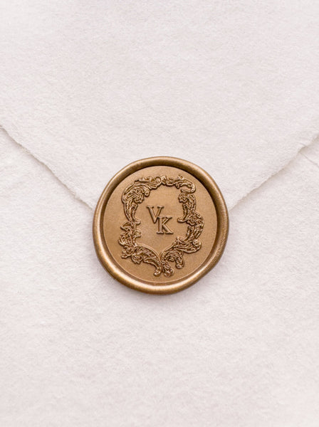 Baroque vintage crest design monogram gold wax seal on a white handmade paper envelope