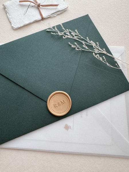 Gold monogram wax seal with a dotted border design