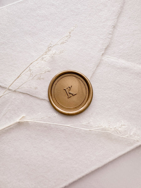 Custom initial gold wax seal with a dotted border design