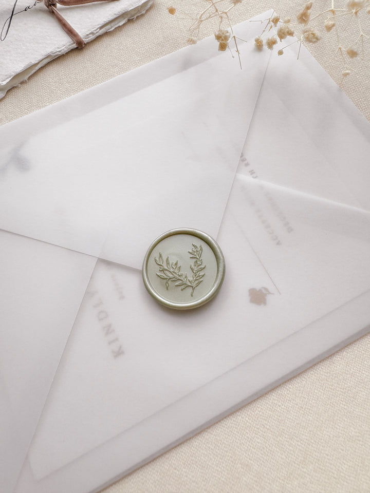 Delicate botanical light sage wax seal on a vellum wedding invitation envelope